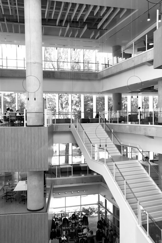 Black and white photo of a contemporary multi-level indoor space, showcasing modern architecture with glass and steel accents.